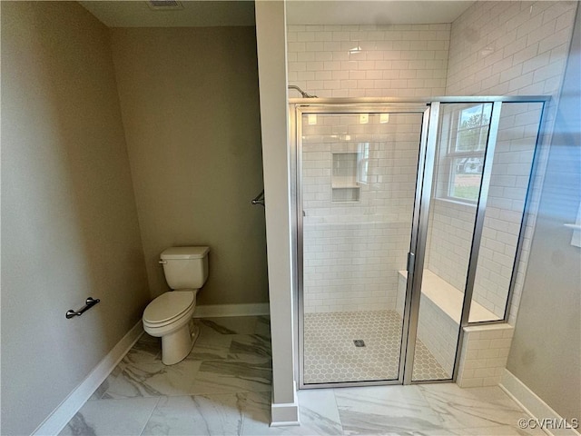 full bathroom featuring marble finish flooring, baseboards, and a stall shower