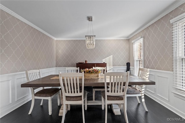 dining space featuring dark hardwood / wood-style floors, crown molding, and a chandelier