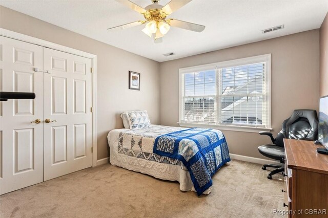carpeted bedroom featuring ceiling fan and a closet