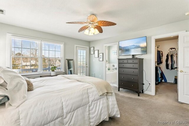 carpeted bedroom featuring connected bathroom, a closet, a spacious closet, and ceiling fan