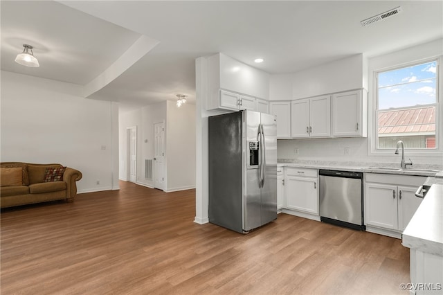 207 E Virginia Ave, Crewe, VA 23930 - kitchen with appliances with stainless steel finishes, light wood-style flooring, open floor plan, white cabinetry, and recessed lighting