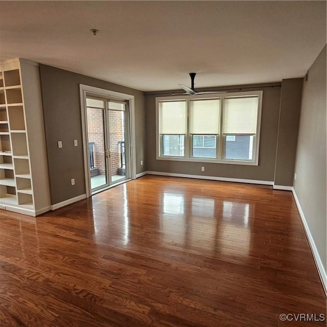 empty room featuring ceiling fan and dark hardwood / wood-style flooring