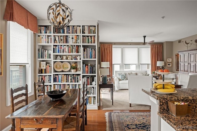 interior space with ceiling fan with notable chandelier, light hardwood / wood-style floors, and a wealth of natural light