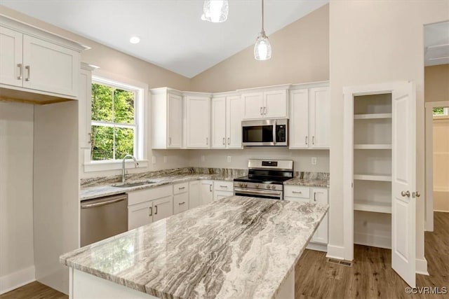 548 Anchor Dr, Bracey, VA 23919 - kitchen with stainless steel appliances, white cabinetry, lofted ceiling, wood finished floors, and a kitchen island