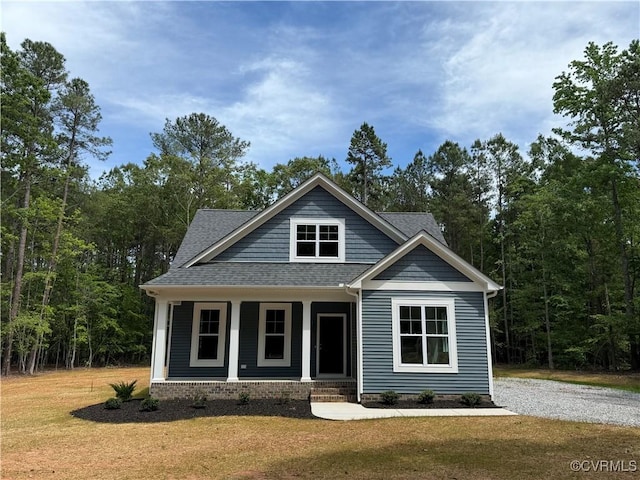 73 Jamestown Ln, Bracey, VA 23919 - view of front of home featuring covered porch, a front lawn, and roof with shingles