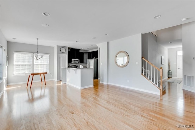 living room featuring light hardwood / wood-style floors and an inviting chandelier