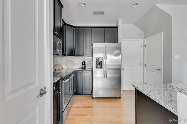 kitchen featuring light stone countertops, stainless steel appliances, tasteful backsplash, and light hardwood / wood-style floors