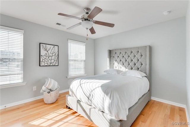 bedroom featuring multiple windows, ceiling fan, and hardwood / wood-style floors