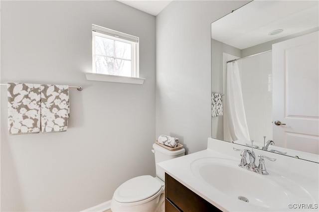 bathroom with walk in shower, vanity, and toilet