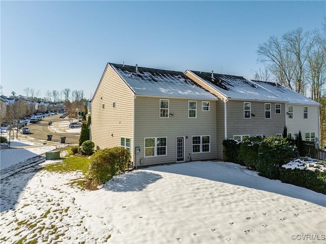 view of snow covered back of property