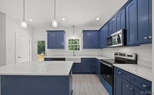 kitchen featuring decorative light fixtures, a kitchen island, blue cabinetry, and appliances with stainless steel finishes