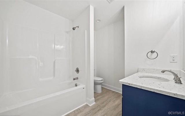 full bathroom featuring hardwood / wood-style floors, vanity, shower / bathtub combination, and toilet