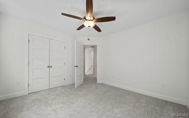 unfurnished bedroom with a closet, light colored carpet, and ceiling fan