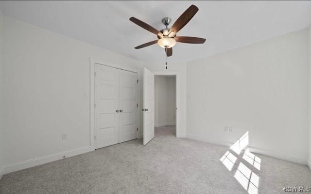 unfurnished bedroom featuring light carpet, a closet, and ceiling fan