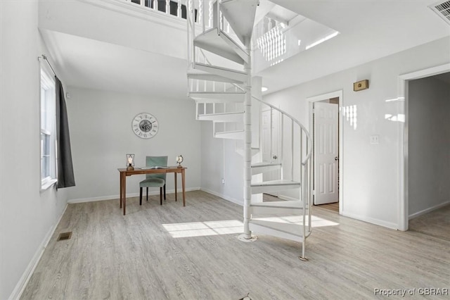 staircase with a high ceiling and hardwood / wood-style flooring