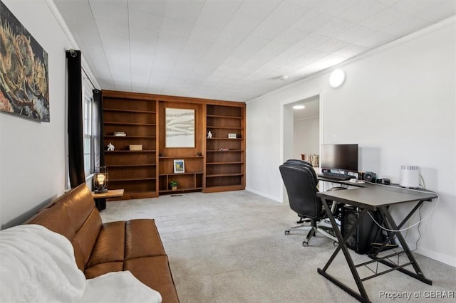 carpeted home office featuring baseboards, built in features, and crown molding