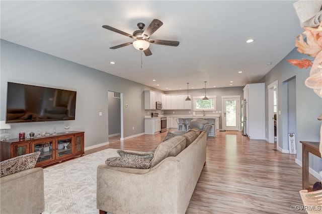 living room featuring ceiling fan and light wood-type flooring