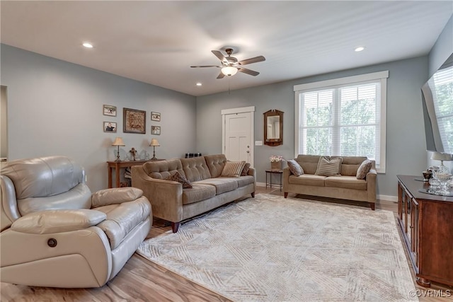 living room with ceiling fan and light wood-type flooring