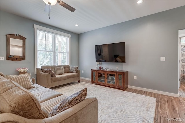 living room with light wood-type flooring and ceiling fan