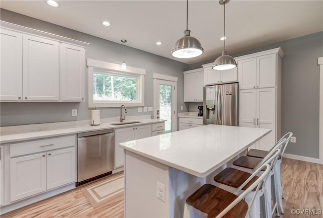 kitchen with a kitchen island, a kitchen bar, white cabinetry, and stainless steel appliances