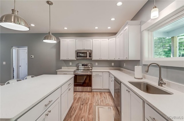 kitchen with appliances with stainless steel finishes, white cabinetry, and sink