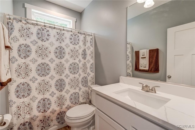 bathroom featuring a shower with curtain, vanity, and toilet