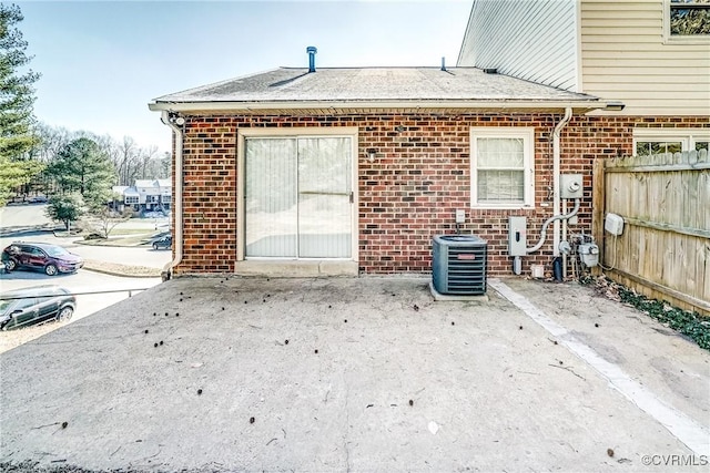 back of property with central air condition unit and a patio area