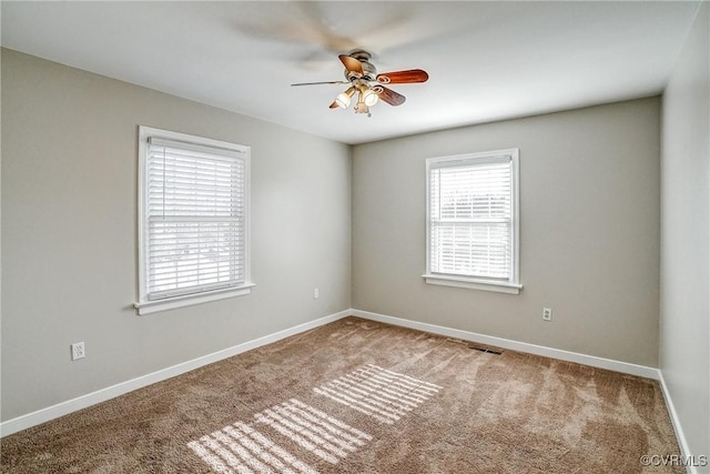 carpeted spare room with ceiling fan and a wealth of natural light