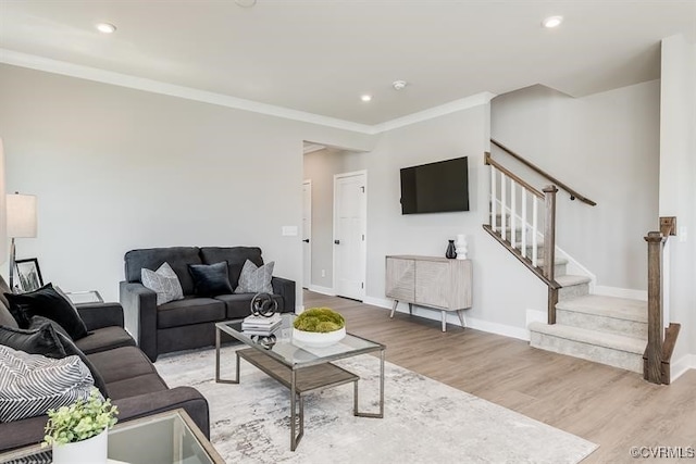 living room featuring light wood-type flooring and crown molding