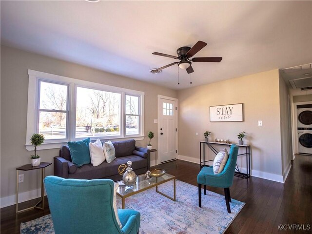 living room with ceiling fan, dark hardwood / wood-style floors, and stacked washing maching and dryer