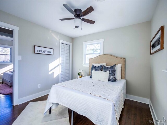 bedroom with ceiling fan, dark hardwood / wood-style flooring, and a closet