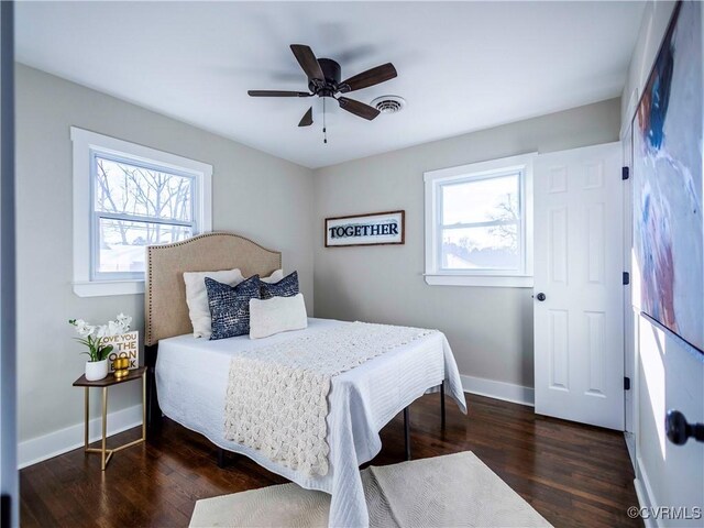 bedroom featuring multiple windows, ceiling fan, and dark hardwood / wood-style flooring