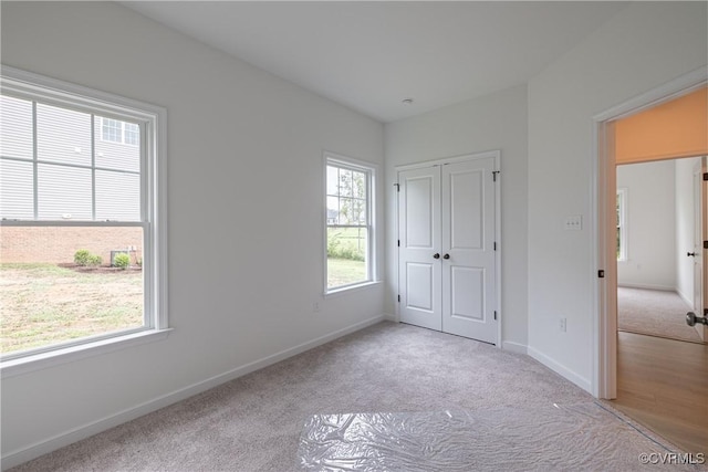 unfurnished bedroom featuring light colored carpet and a closet