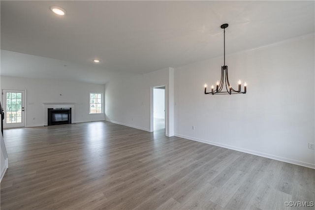 unfurnished living room featuring hardwood / wood-style floors and a notable chandelier