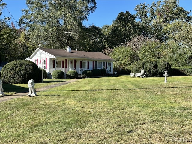 ranch-style home featuring covered porch and a front lawn