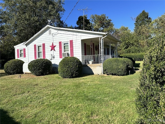 view of property exterior featuring a lawn, cooling unit, and covered porch