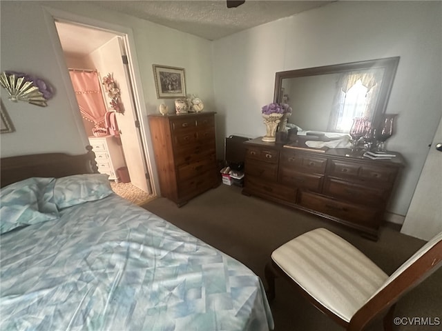 bedroom with a textured ceiling and dark carpet