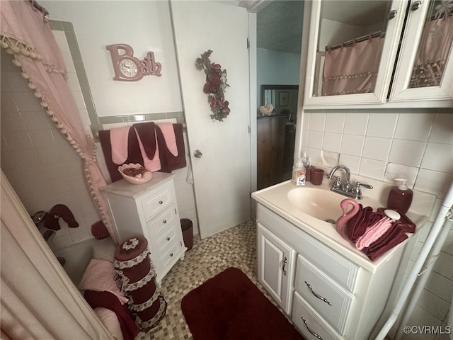 bathroom with vanity, backsplash, tile walls, and walk in shower