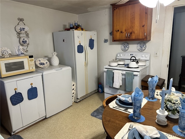 kitchen featuring white appliances and separate washer and dryer