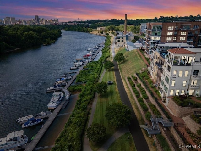 aerial view at dusk featuring a water view