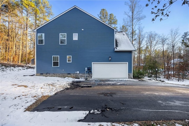 view of snow covered exterior with a garage