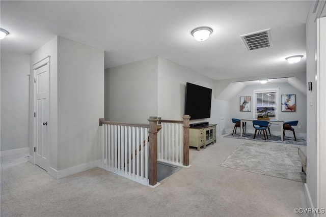 additional living space featuring light colored carpet and vaulted ceiling