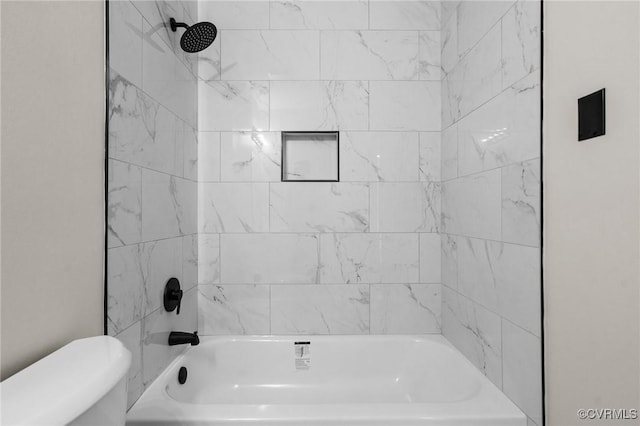 bathroom featuring toilet and tiled shower / bath