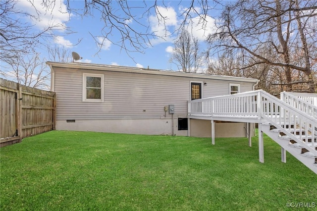 back of property featuring a lawn and a deck