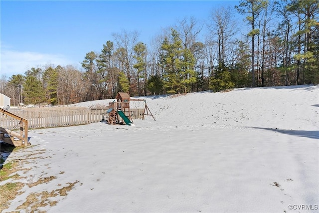 yard covered in snow with a playground