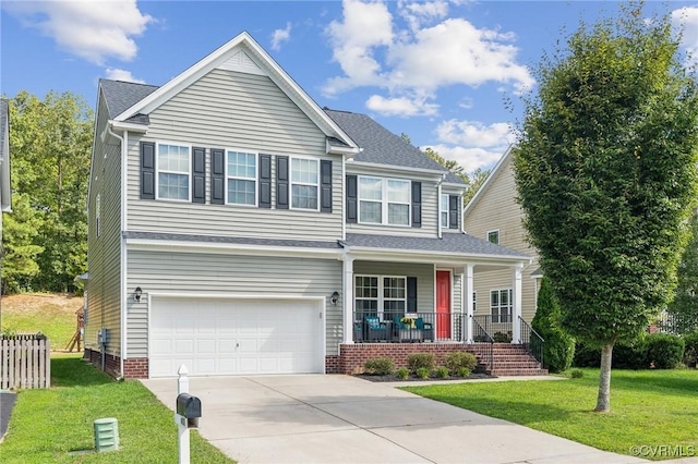 view of front of home featuring covered porch, a garage, and a front lawn