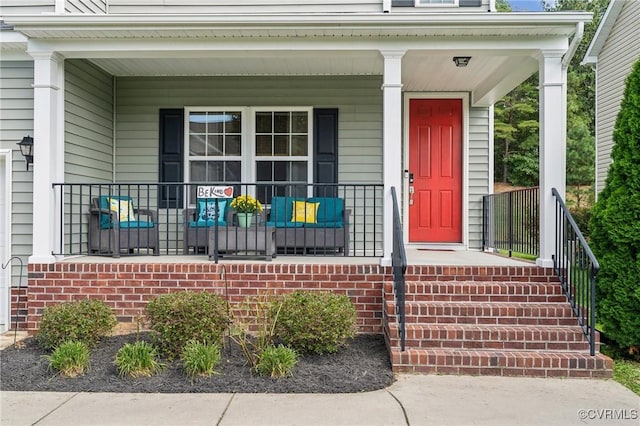 doorway to property featuring covered porch and brick siding