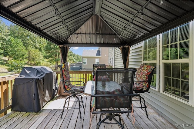 wooden deck with a gazebo, outdoor dining area, and area for grilling