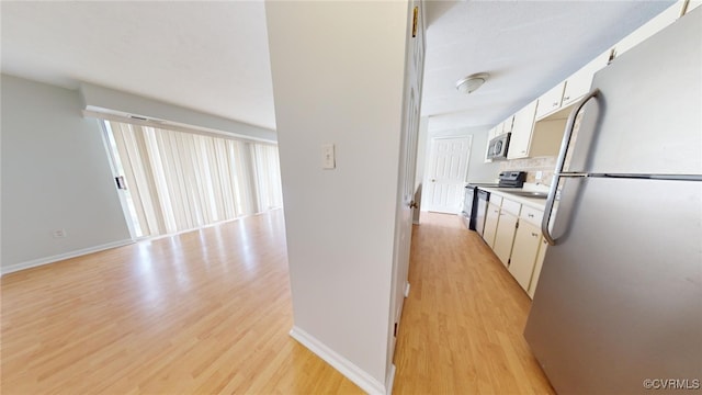 interior space featuring light wood-type flooring, white cabinetry, and stainless steel appliances