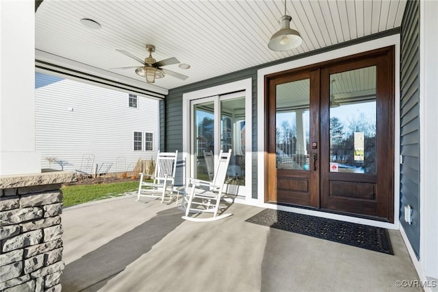 view of exterior entry featuring ceiling fan, french doors, and a porch